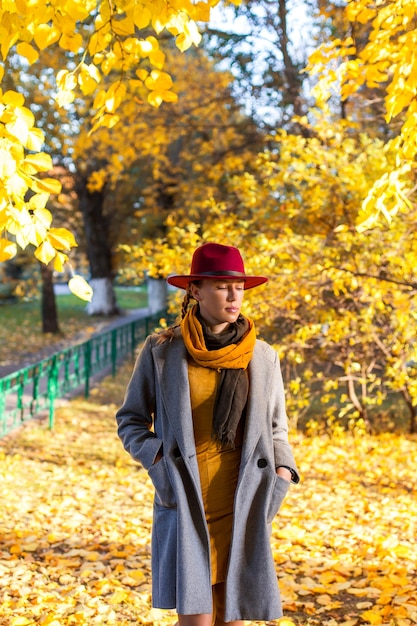 Chica guapa caminando en la ciudad de otoño