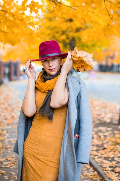 Chica guapa caminando en la ciudad de otoño