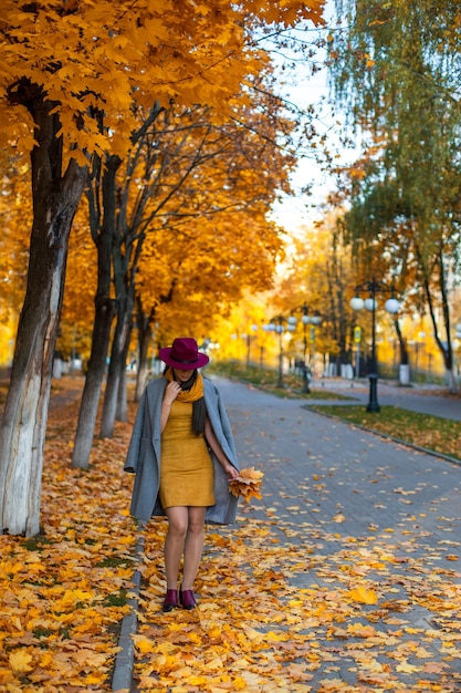 Chica guapa caminando en la ciudad de otoño