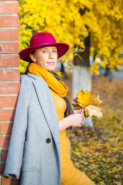 Chica guapa caminando en la ciudad de otoño