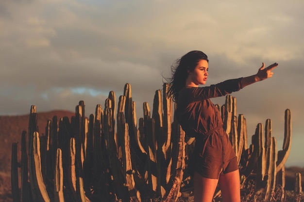 Chica guapa con camisa sexi marrón en cactus del desierto