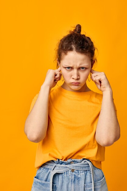 Chica guapa en una camiseta amarilla posando emociones fondos aislados inalterados