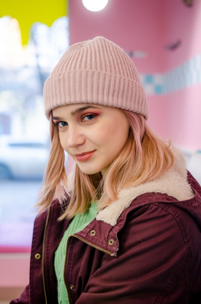 Chica guapa en chaqueta sentado en café americano retro