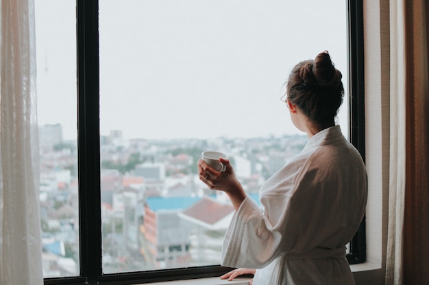 Chica guapa disfrutando del café por la mañana en el hotel