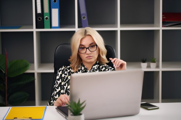 Chica guapa en el escritorio de la computadora para llevar el pedido a casa. Ejecución de mujer europea de negocios en línea.