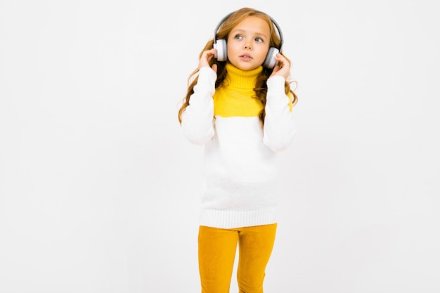 Chica guapa escuchando música en grandes auriculares blancos