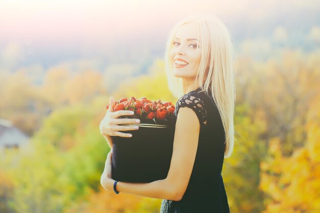 Chica guapa con flores en caja