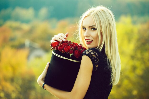 Chica guapa con flores en caja