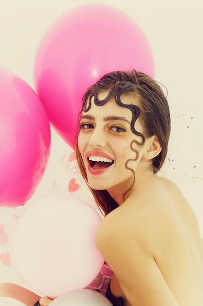 Chica guapa con globos de fiesta rosa aislado en blanco