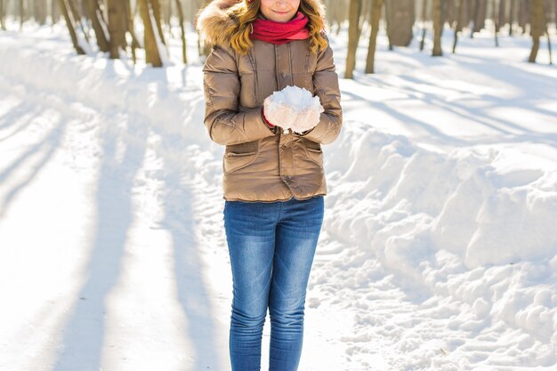 Chica guapa joven con nieve en guantes.