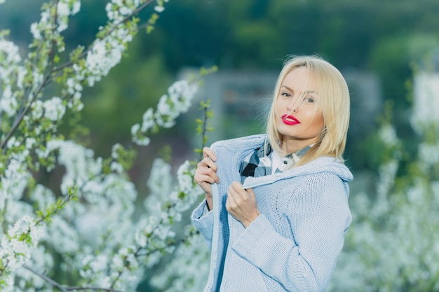 Chica guapa con labios rojos y cabello rubio en flor