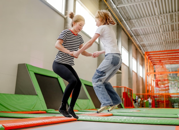 Chica guapa en el parque de trampolines divirtiéndose