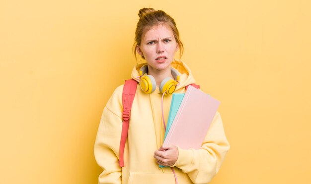 Chica guapa pelirroja sintiéndose desconcertada y confundida concepto de estudiante