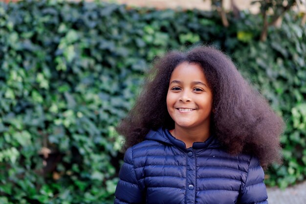 Chica guapa con pelo largo afro en el jardín