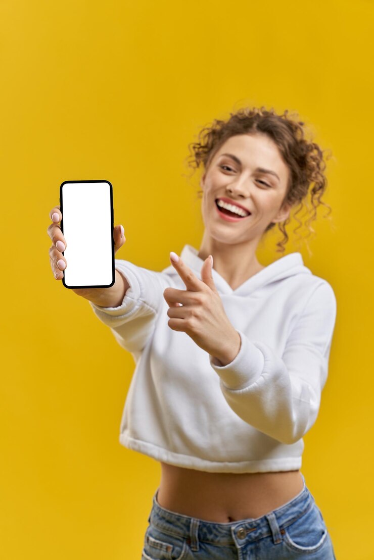 Chica guapa de pie con smartpone en la mano