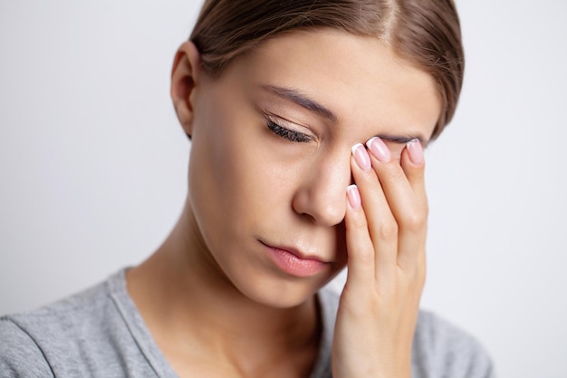 La chica guapa siente un dolor severo alrededor de los ojos.