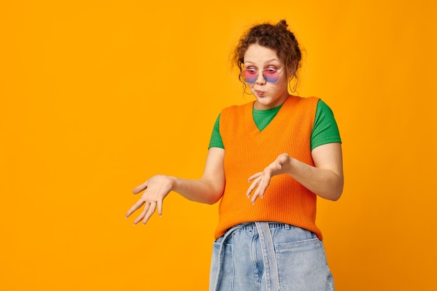 Chica guapa sudaderas naranjas gafas de sol gafas multicolores suministro vista recortada inalterada