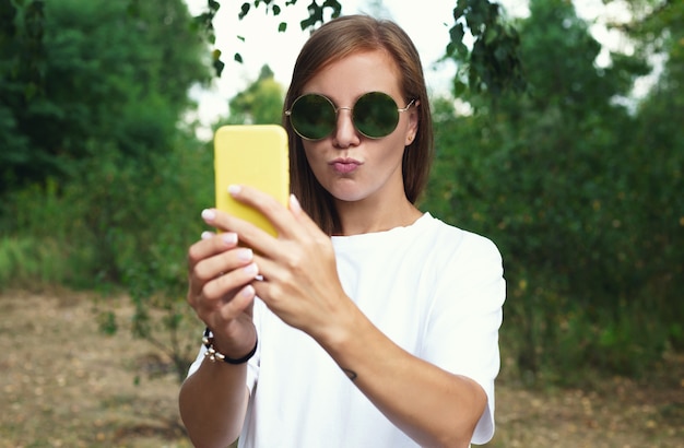 Chica guapa toma un autorretrato con su teléfono inteligente