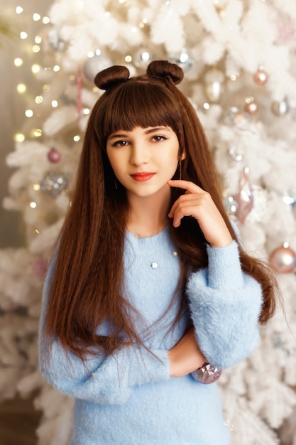 Chica en una habitación con árbol de Navidad y adornos