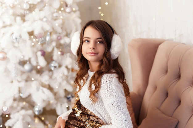 Chica en una habitación con árbol de Navidad y adornos