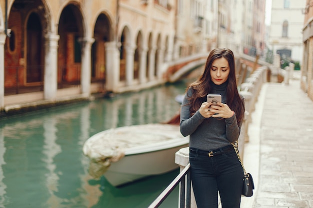 chica hablando por teléfono y tomando fotos en Venecia Italia