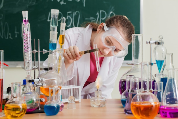 Chica hace un experimento químico en una clase de química