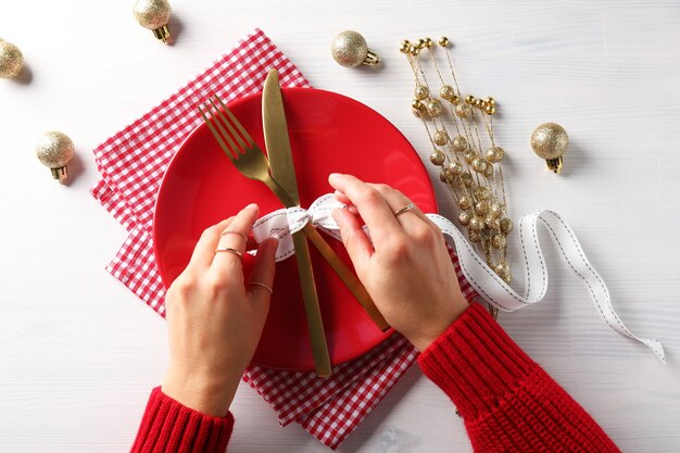 Chica hace mesa de año nuevo en mesa de madera blanca.