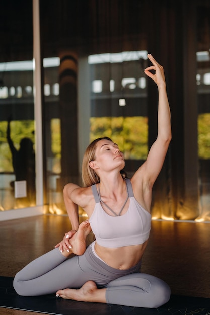 La chica hace yoga Una mujer con ropa deportiva hace ejercicios de yoga en el gimnasio