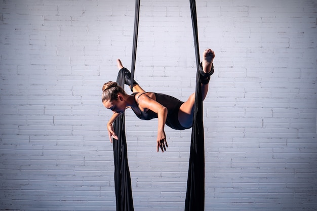 Chica haciendo acrobacias aéreas sobre sedas