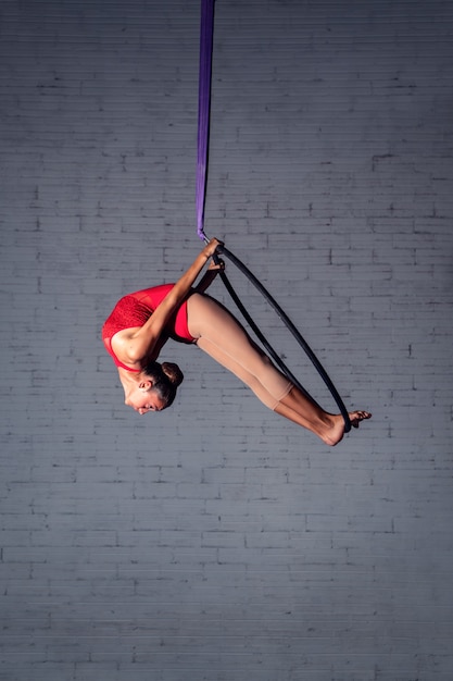 Chica haciendo acrobacias aéreas sobre sedas