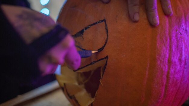 Foto chica haciendo una calabaza de halloween