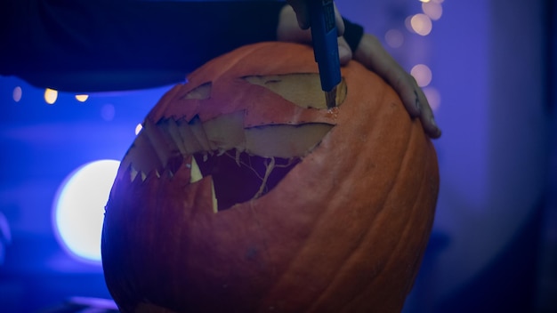 Foto chica haciendo una calabaza de halloween