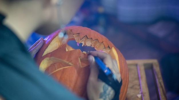 Chica haciendo una calabaza de halloween