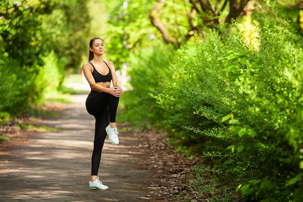 Chica haciendo deporte. Joven mujer haciendo ejercicio en un parque