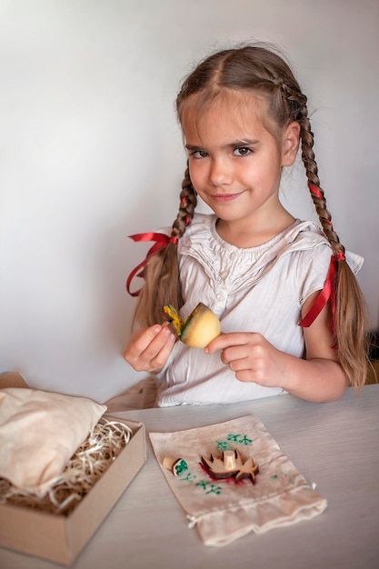 Chica haciendo envoltura artesanal para regalos festivos con técnica de impresión de sellos