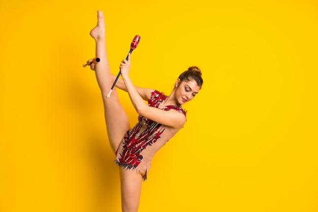 Chica haciendo gimnasia rítmica con mazas.