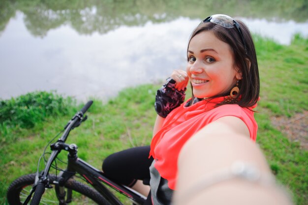 Foto chica haciendo selfie en bicicleta