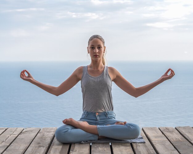 Chica haciendo yoga en el fondo del mar