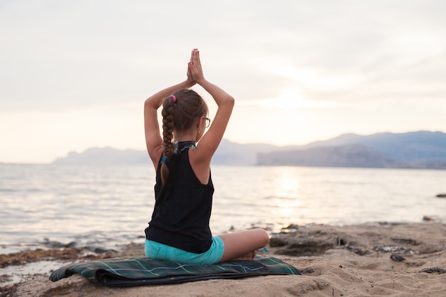 Chica haciendo yoga en la naturaleza al aire libre al amanecer