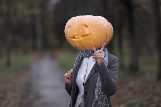 Chica de Halloween con cabeza de calabaza