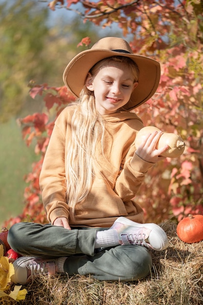 Chica en el heno con calabazas