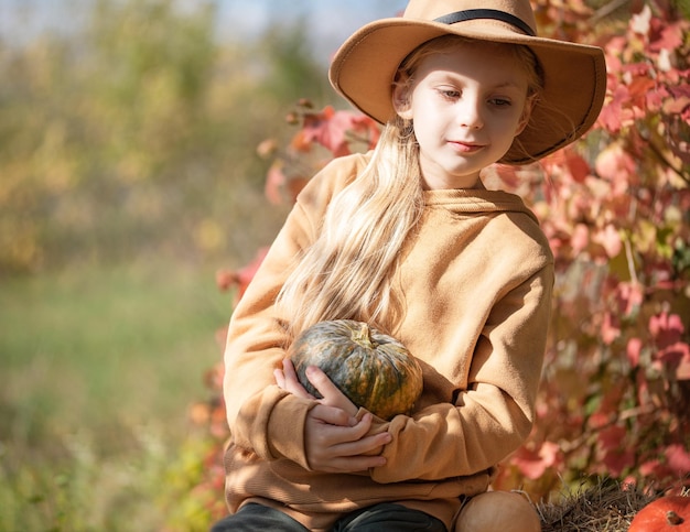 Chica en el heno con calabazas