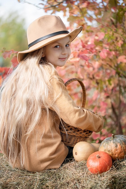 Chica en el heno con calabazas