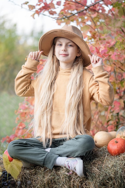 Chica en el heno con calabazas