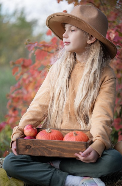 Chica en el heno con calabazas