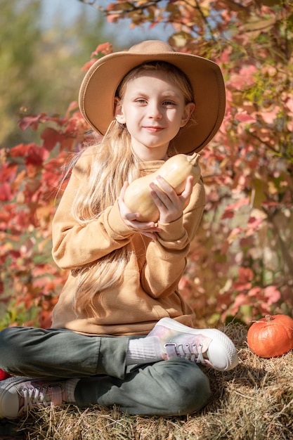 Chica en el heno con calabazas