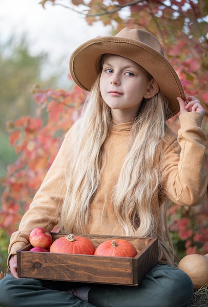 Chica en el heno con calabazas