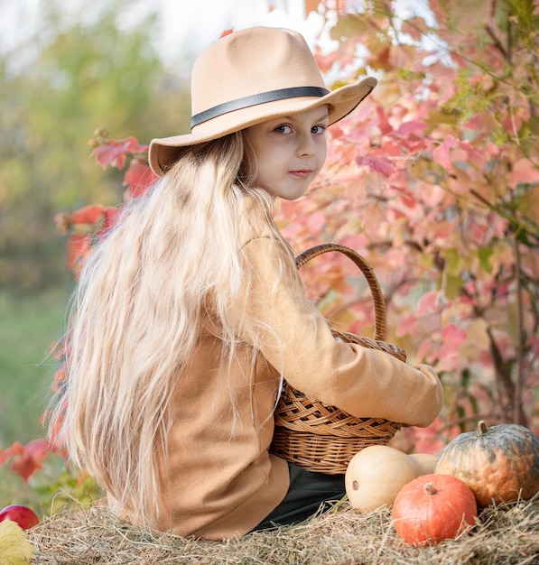 Chica en el heno con calabazas