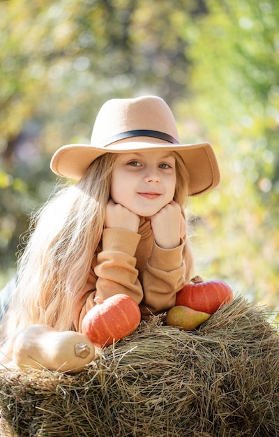 Chica en el heno con calabazas