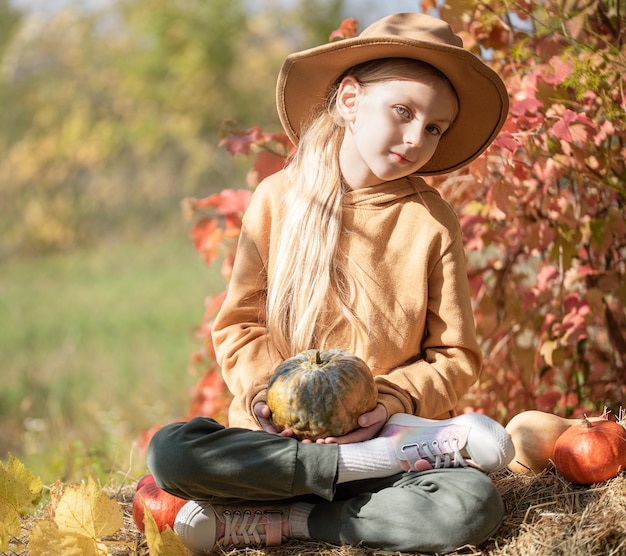 Chica en el heno con calabazas